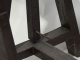 a close up of a wooden stool with a nail on it