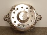 a silver bowl with a handle on a table