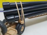 a toy truck with a bunch of black pipes on it