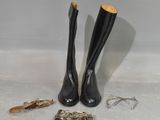 une paire de bottes en cuir noir ornées de garnitures dorées et une paire de chaussures ornées de garnitures dorées