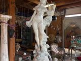 a statue of a woman holding a book in a room