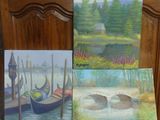 trois tableaux représentant des bateaux sont posés sur une table en bois à côté d'une chaise