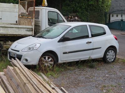 une petite voiture blanche garée devant un camion