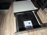 an open drawer with a computer in it on the floor