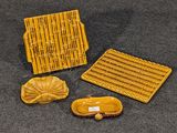 trois pièces de poterie jaune posées sur une surface noire