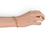 gold plated bracelet with yellow beads on a mannequin hand