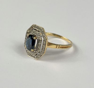 gros plan d'une bague avec un saphir et des diamants