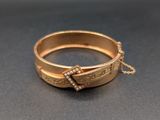 un gros plan d'une bague en or entourée d'une chaîne