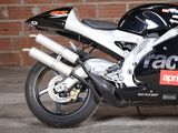 a black motorcycle parked in front of a brick wall