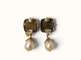 two pairs of earrings with pearls on them sitting on a white surface