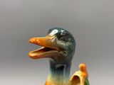 un canard en céramique assis à côté d'un œuf cassé