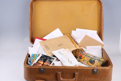 une valise marron remplie de courrier et d'autres objets