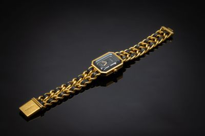 a close up of a gold wrist watch on a black background
