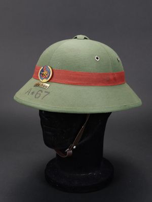 un casque vert militaire orné d'un bandeau rouge et d'un insigne
