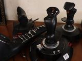 a lot of joysticks sitting on a wooden table