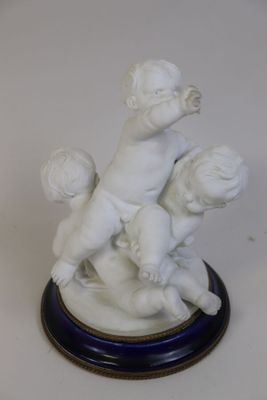 une petite statue représentant un garçon et une fille jouant avec un ballon