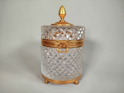 a glass jar with a gold lid sitting on a table