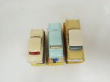 three toy cars are lined up in a row on a white surface