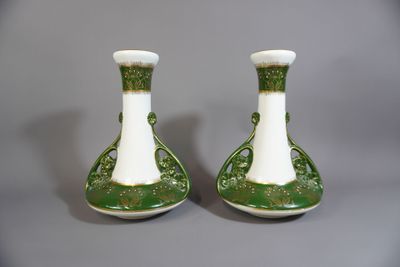 une paire de vases verts et blancs posés sur une table