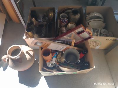 une boîte remplie de tasses à café et d'autres objets, posée par terre