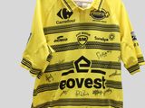 un gros plan sur un maillot de foot jaune suspendu à un cintre