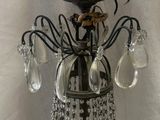 a chandelier that has a bird on top of it
