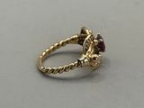 an image of a gold ring with a garnet stone in the center