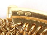 a close up picture of a gold chain bracelet with a clasp