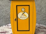 une petite armoire jaune surmontée d'une horloge