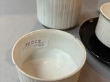 a cup and saucer sitting on a table next to a plate