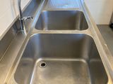 a stainless steel sink in the corner of a kitchen