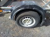 a trailer that has a flat tire on the side of it