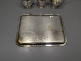 a silver tray with three salt and pepper shakers on it