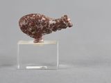 un gros plan d'une figurine représentant un mouton posée sur un socle transparent