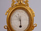 a gold clock hanging from the side of a building
