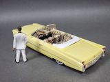 a man standing next to a toy car with a cat in it