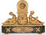 une horloge en or sur laquelle sont assises trois femmes
