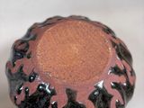 a close up of a brown and black ceramic knob