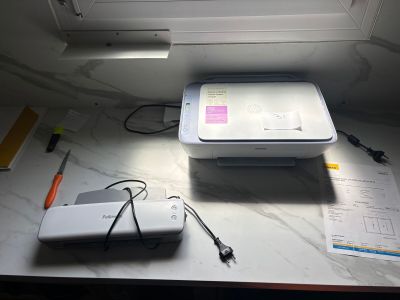 a white printer sitting on top of a table next to a window