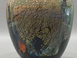 a black vase with a multicolored design on it