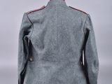 the back of a grey jacket with red trims and buttons