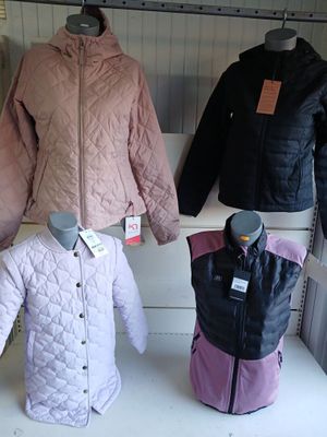 several jackets and jackets on display in a store window