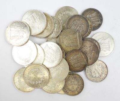 un tas d'argent et de pièces d'argent posé sur une surface blanche