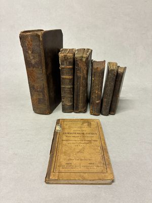 plusieurs vieux livres posés sur une table, à côté d'un livre