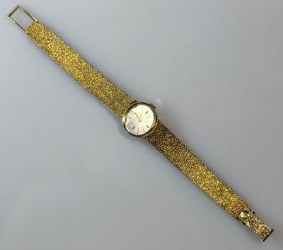 a gold watch with a white face on a white surface