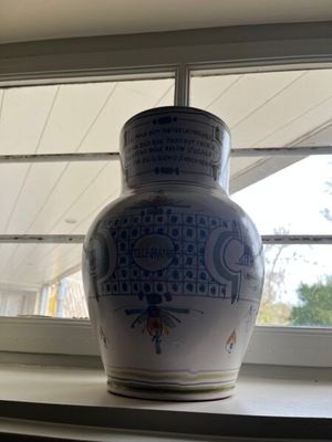un vase bleu et blanc posé sur le rebord d'une fenêtre
