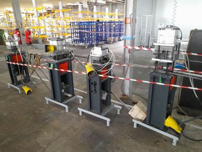 many machines that are in a warehouse with red and white tape