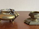 une petite théière en laiton et une petite théière en argent posées sur une table