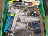 une boîte verte remplie de stylos et d'autres fournitures de bureau