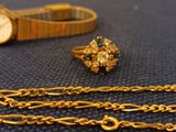 a gold bracelet and a gold watch on a table